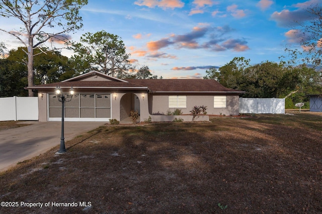 single story home with a garage and a lawn