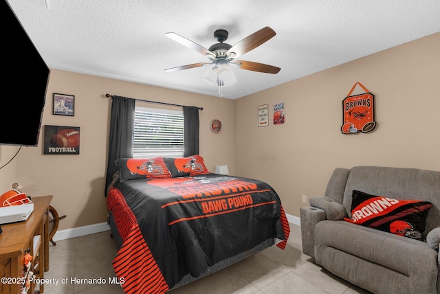 tiled bedroom with ceiling fan and a textured ceiling