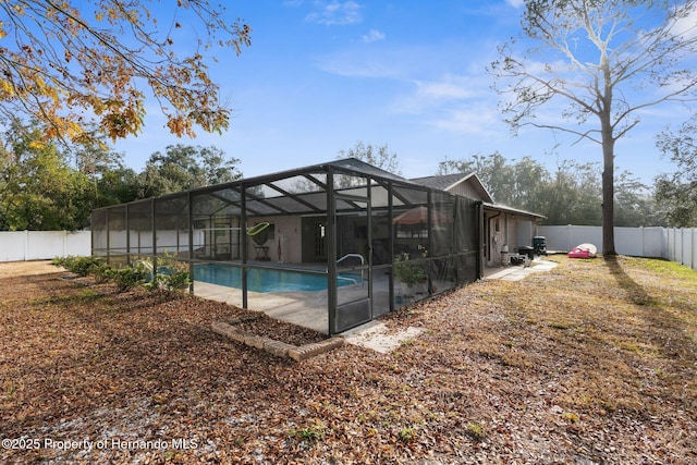 view of swimming pool featuring a patio area and glass enclosure