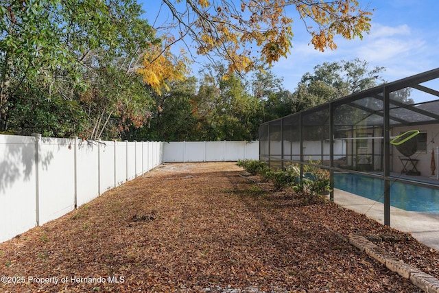 view of yard with a lanai and a fenced in pool