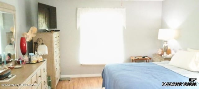 bedroom with baseboards and light wood-type flooring