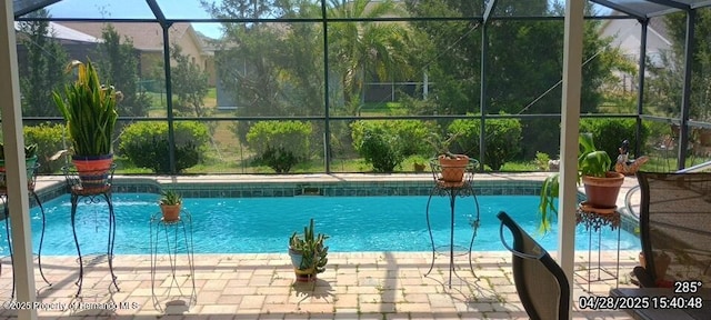 pool featuring a patio area and glass enclosure