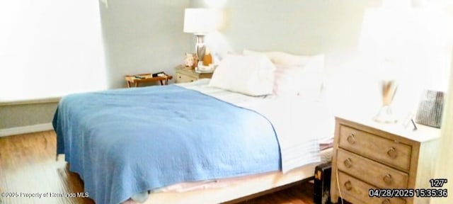 bedroom featuring wood finished floors and baseboards