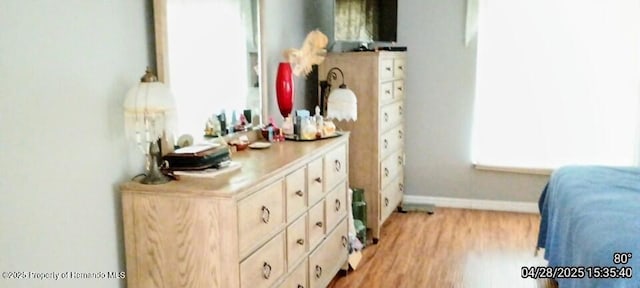 bedroom with light wood-style flooring and baseboards