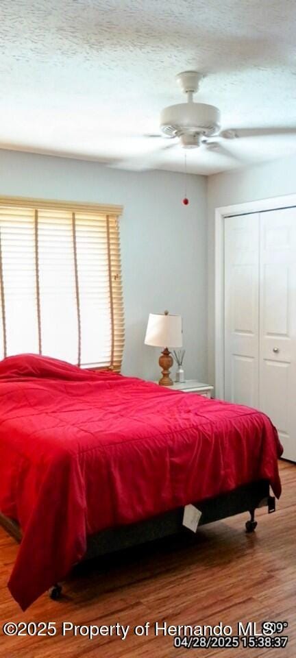 bedroom with a closet, wood finished floors, and a textured ceiling