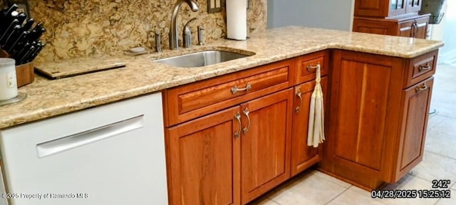 kitchen featuring a sink, light tile patterned flooring, white dishwasher, tasteful backsplash, and light stone counters