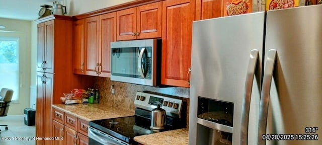 kitchen with appliances with stainless steel finishes, light stone counters, brown cabinets, and decorative backsplash