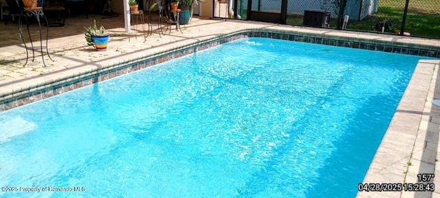 outdoor pool featuring a patio and fence