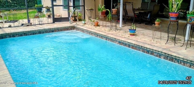 outdoor pool with a lanai and a patio area