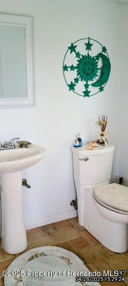 bathroom with baseboards and toilet