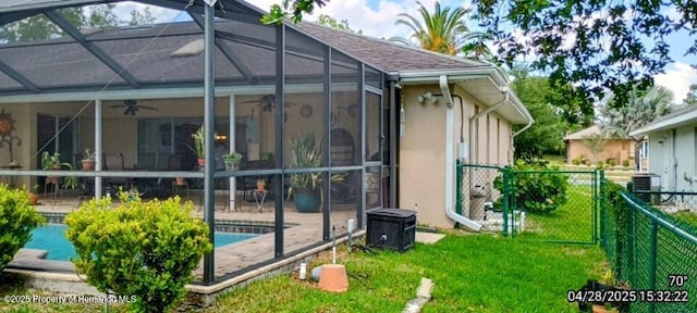 view of home's exterior featuring stucco siding, fence, central air condition unit, a ceiling fan, and a lawn