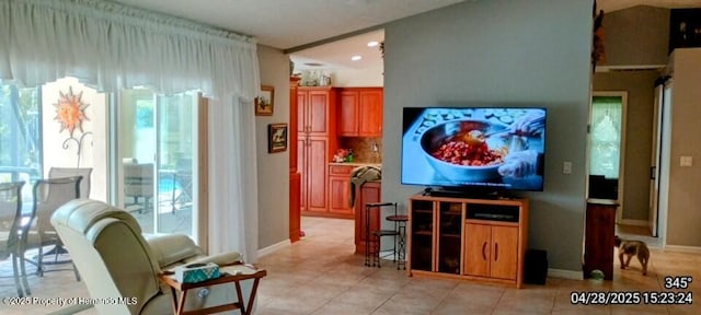 living room featuring light tile patterned floors, a healthy amount of sunlight, and baseboards