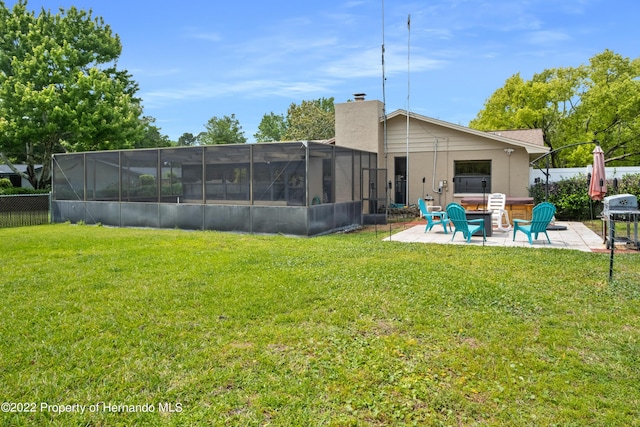 rear view of house with a lanai, a patio area, and a lawn