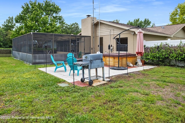 rear view of house with a patio, a yard, glass enclosure, a hot tub, and a sunroom
