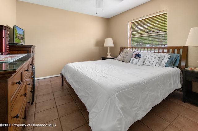 tiled bedroom featuring ceiling fan
