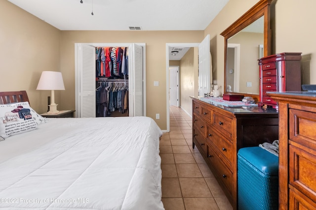 bedroom with light tile patterned floors and a closet