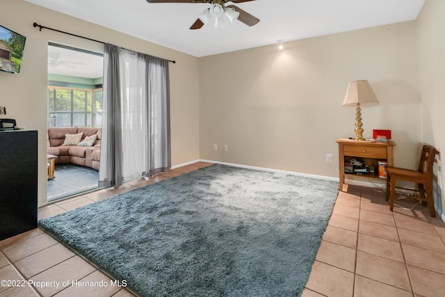 living area with ceiling fan and light tile patterned flooring