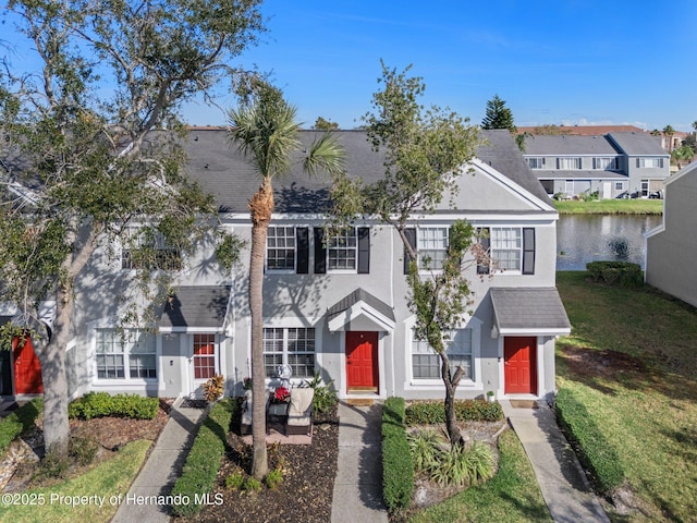 view of front of house with a front lawn and a water view