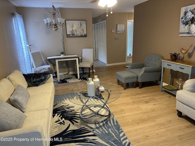 living room featuring a chandelier and light wood-type flooring