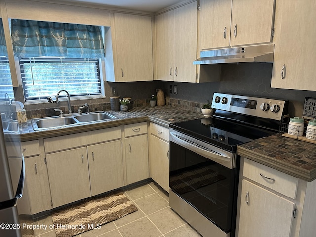 kitchen featuring light brown cabinetry, tasteful backsplash, sink, light tile patterned floors, and electric stove