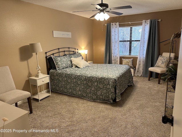 bedroom with ceiling fan, carpet floors, and a textured ceiling