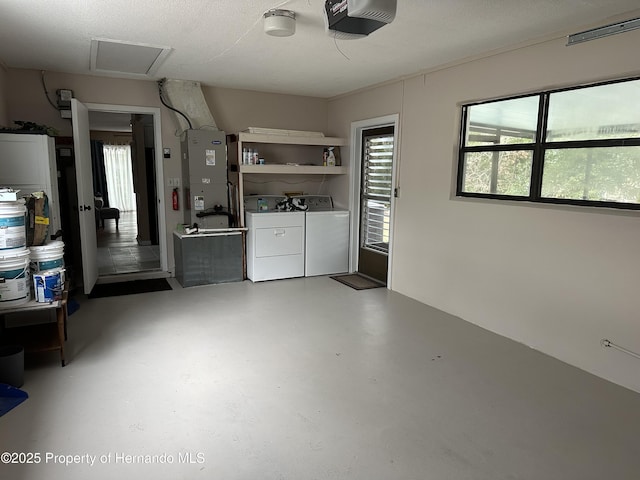 garage featuring separate washer and dryer, a garage door opener, and heating unit