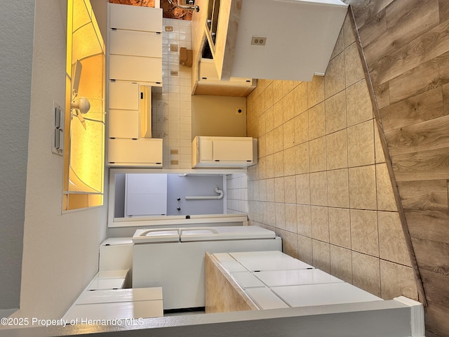 kitchen with tile walls, washer / clothes dryer, and tile countertops