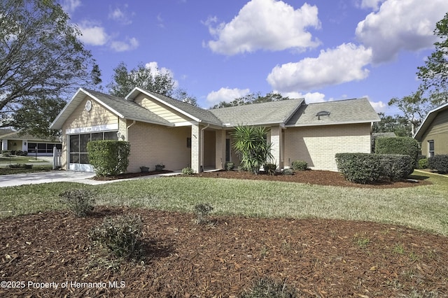 ranch-style home featuring a garage and a front lawn