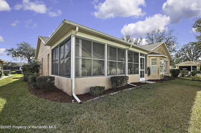 view of property exterior with a sunroom and a yard