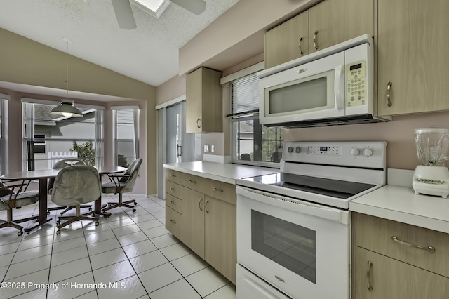 kitchen with vaulted ceiling, plenty of natural light, pendant lighting, and white appliances