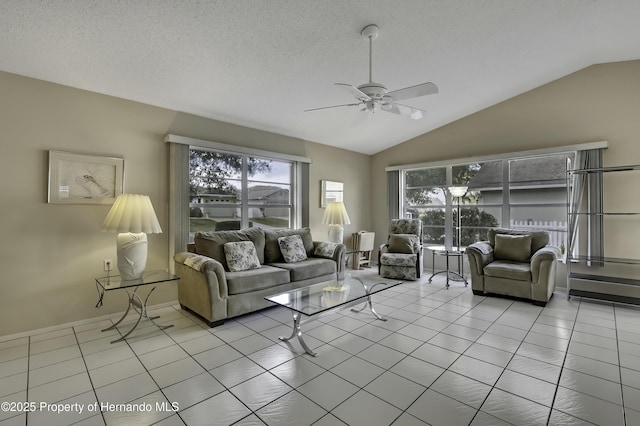 living room featuring light tile patterned floors, vaulted ceiling, a textured ceiling, and ceiling fan