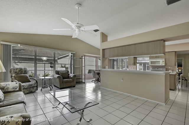 tiled living room featuring ceiling fan, plenty of natural light, high vaulted ceiling, and a textured ceiling