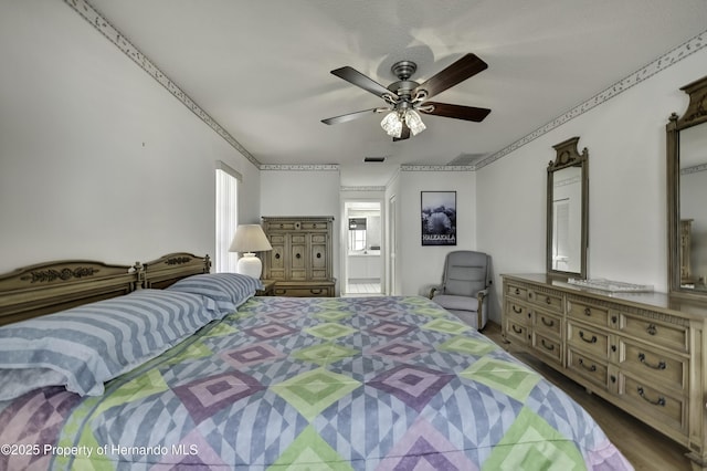 bedroom with crown molding, ceiling fan, and ensuite bathroom