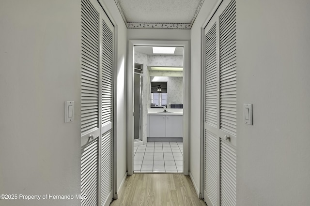 hall featuring sink and light wood-type flooring