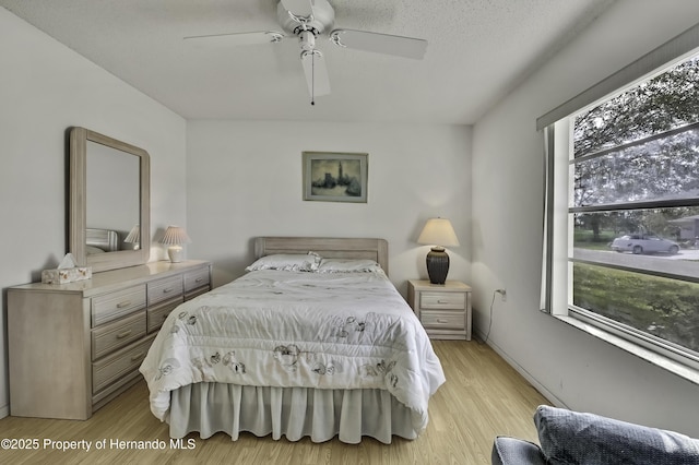 bedroom with light hardwood / wood-style flooring and ceiling fan