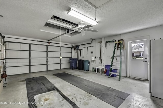 garage with a garage door opener, fridge, and ceiling fan