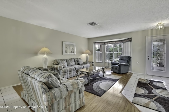 living room with a textured ceiling and light hardwood / wood-style floors