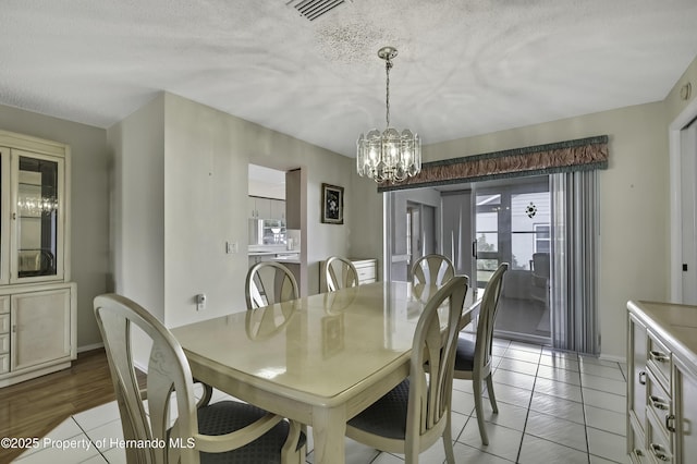 dining space featuring a textured ceiling and a notable chandelier