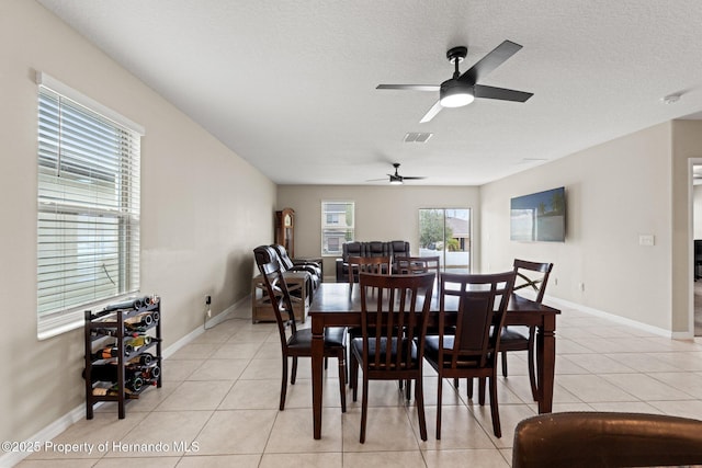 tiled dining space with a textured ceiling