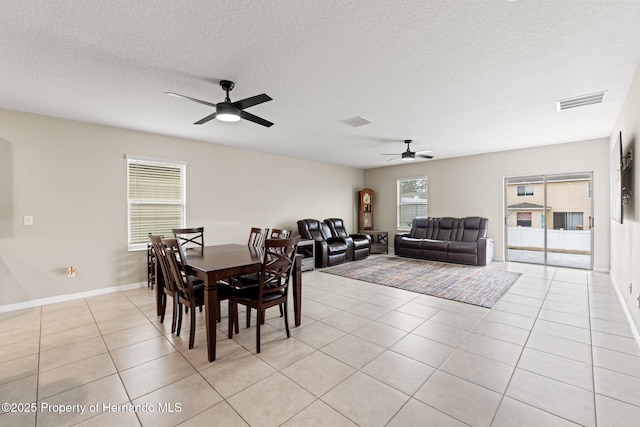 tiled dining room featuring ceiling fan and a textured ceiling