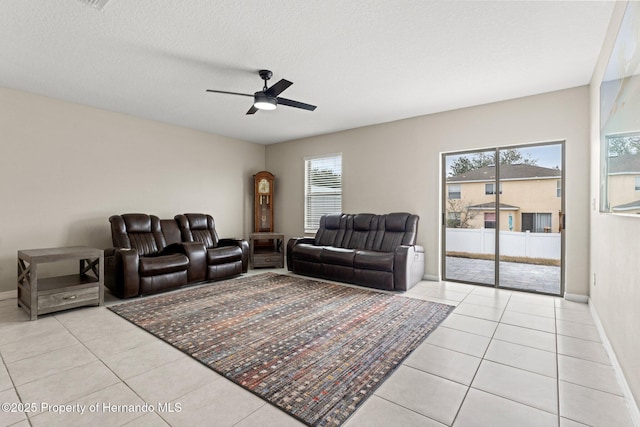 tiled living room featuring ceiling fan, plenty of natural light, and a textured ceiling