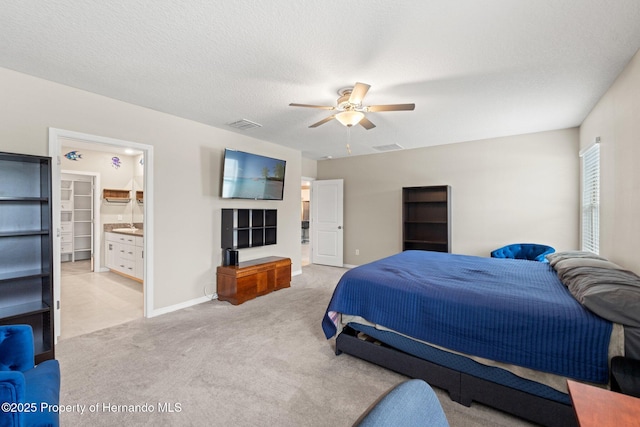 bedroom featuring ceiling fan, light carpet, and a textured ceiling