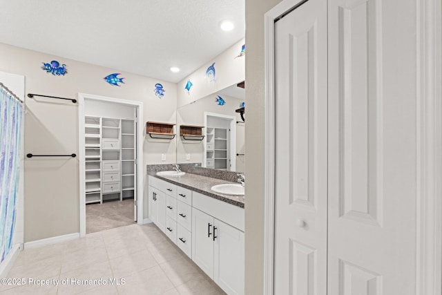 bathroom featuring walk in shower, vanity, tile patterned flooring, and a textured ceiling