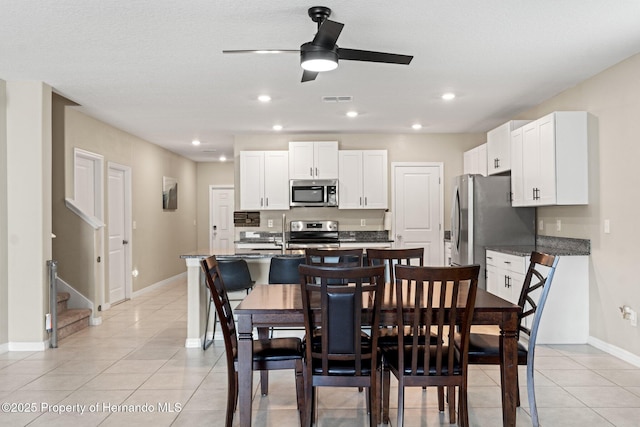 tiled dining space featuring ceiling fan and sink