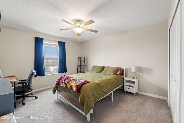 carpeted bedroom featuring ceiling fan, a textured ceiling, and a closet