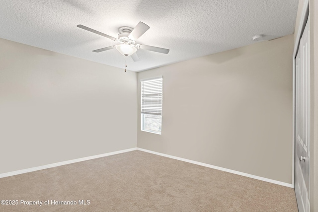 spare room featuring light colored carpet, a textured ceiling, and ceiling fan