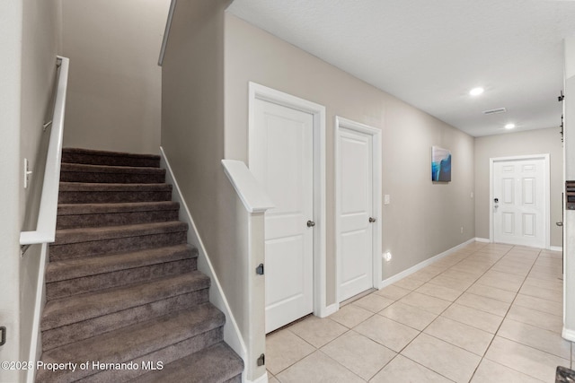 stairs featuring tile patterned flooring