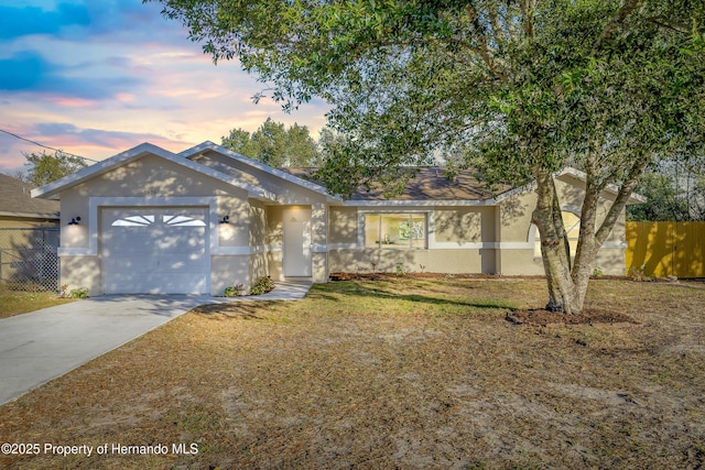 ranch-style house with a garage and a yard