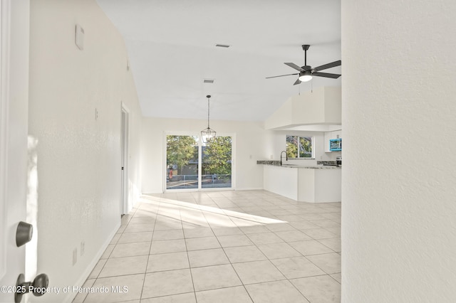 unfurnished living room featuring ceiling fan, high vaulted ceiling, sink, and light tile patterned floors