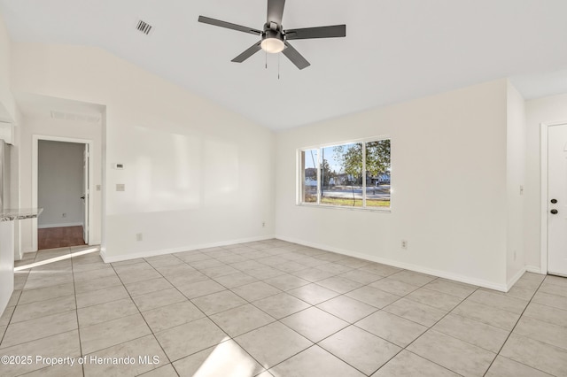 tiled empty room featuring lofted ceiling and ceiling fan